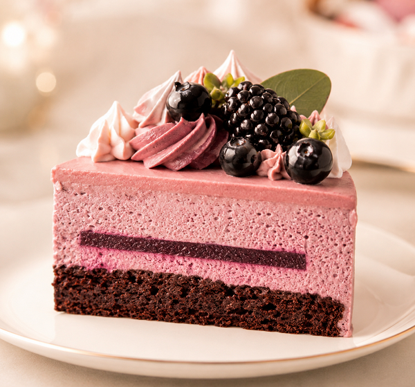 Beeren-Schokoladenkuchen auf Cremeplatte Beeren-Schokoladenkuchen-auf-Cremeplatte auf einem Teller